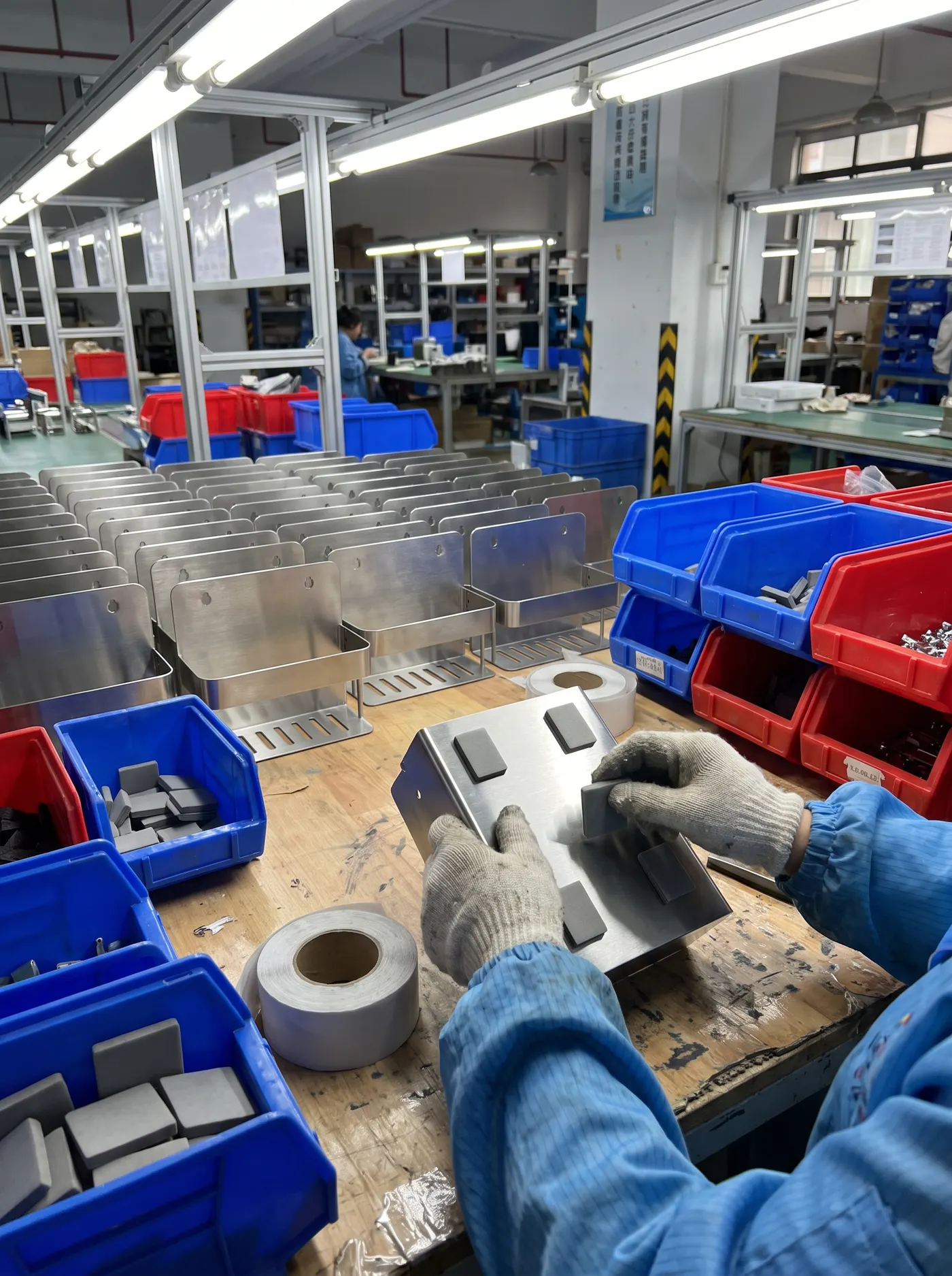 Adhesive mounting pads applied to stainless-steel shelves during assembly