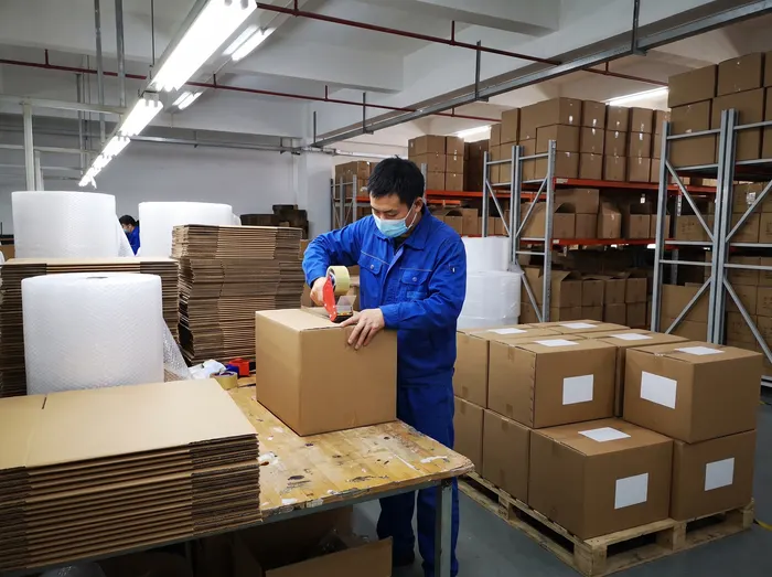 Packed cartons moving along a packing line at a partner factory