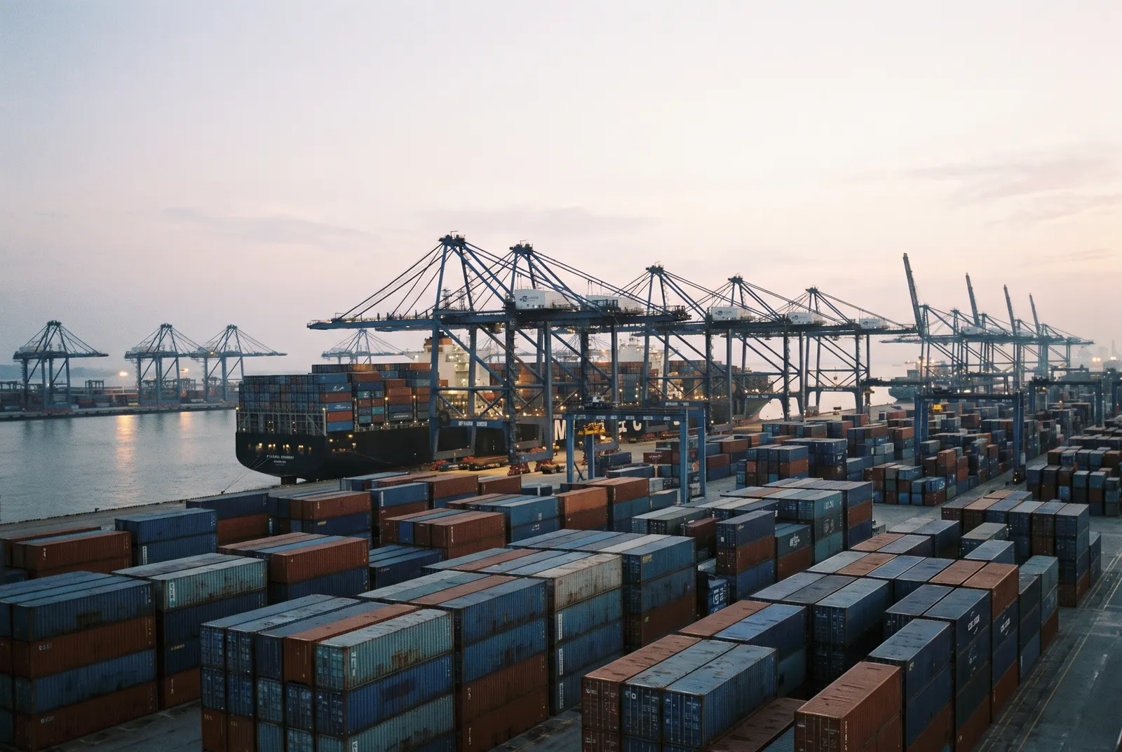 Gantry cranes loading a container ship at Ningbo-Zhoushan port at dusk